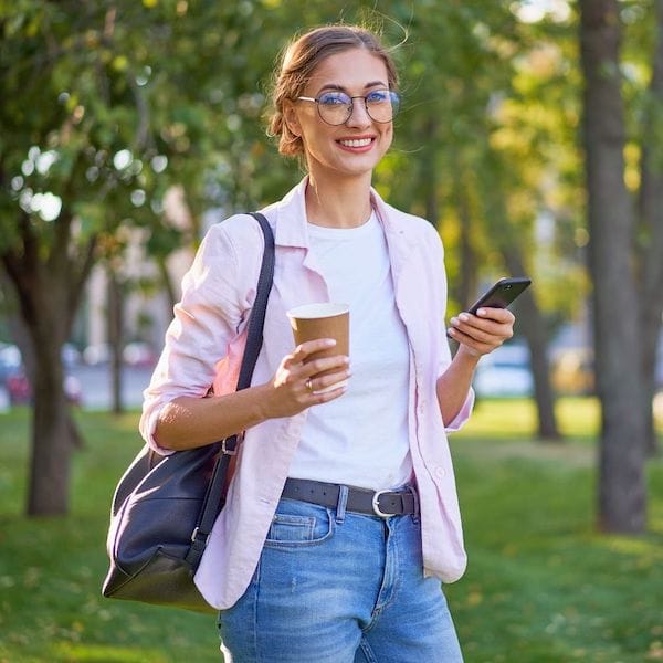 casual business woman holding coffee and her phone