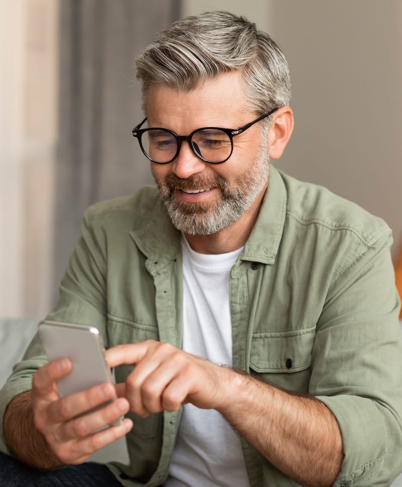 smiling elderly man looking at his phone
